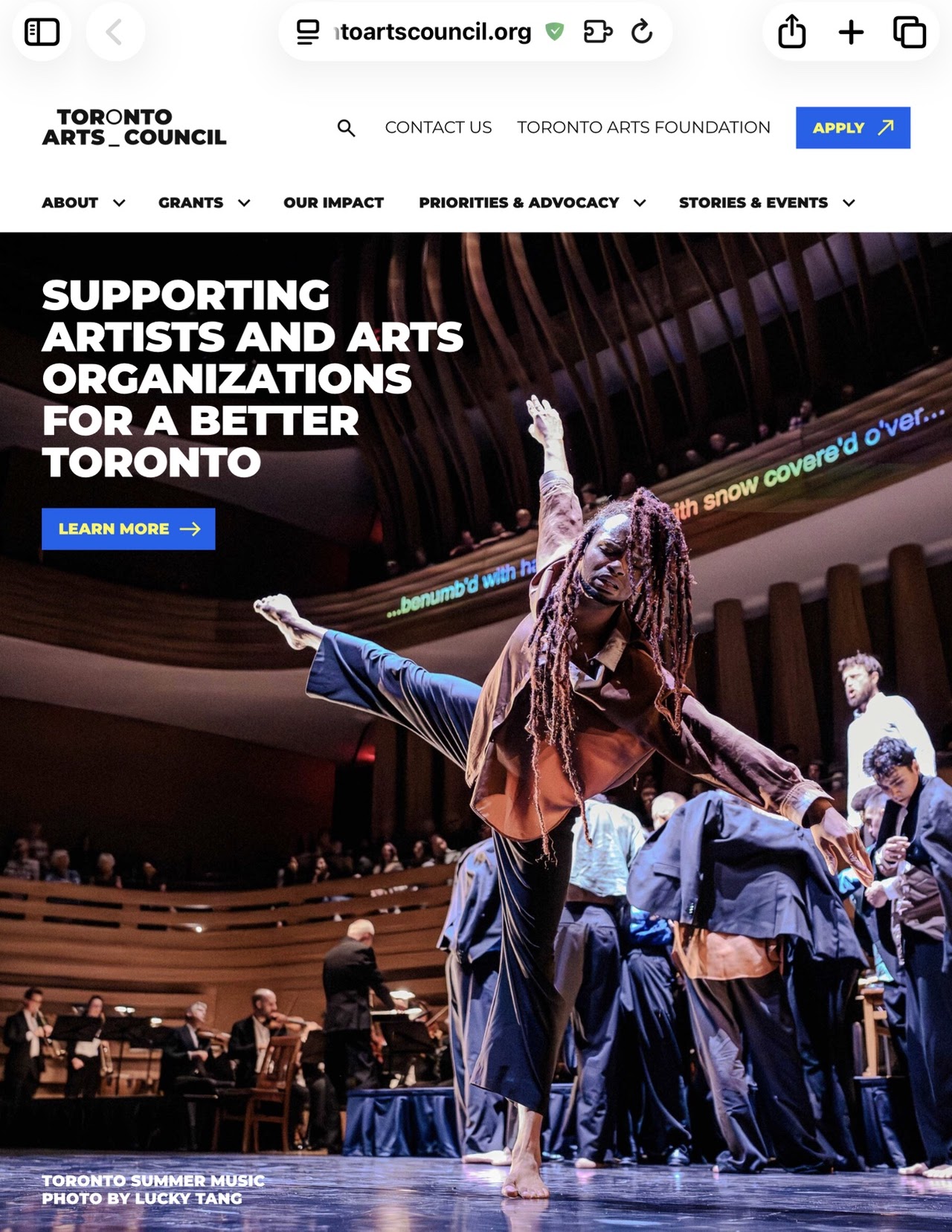 Musicians performing on stage with pianist at grand piano and cellist playing cello.